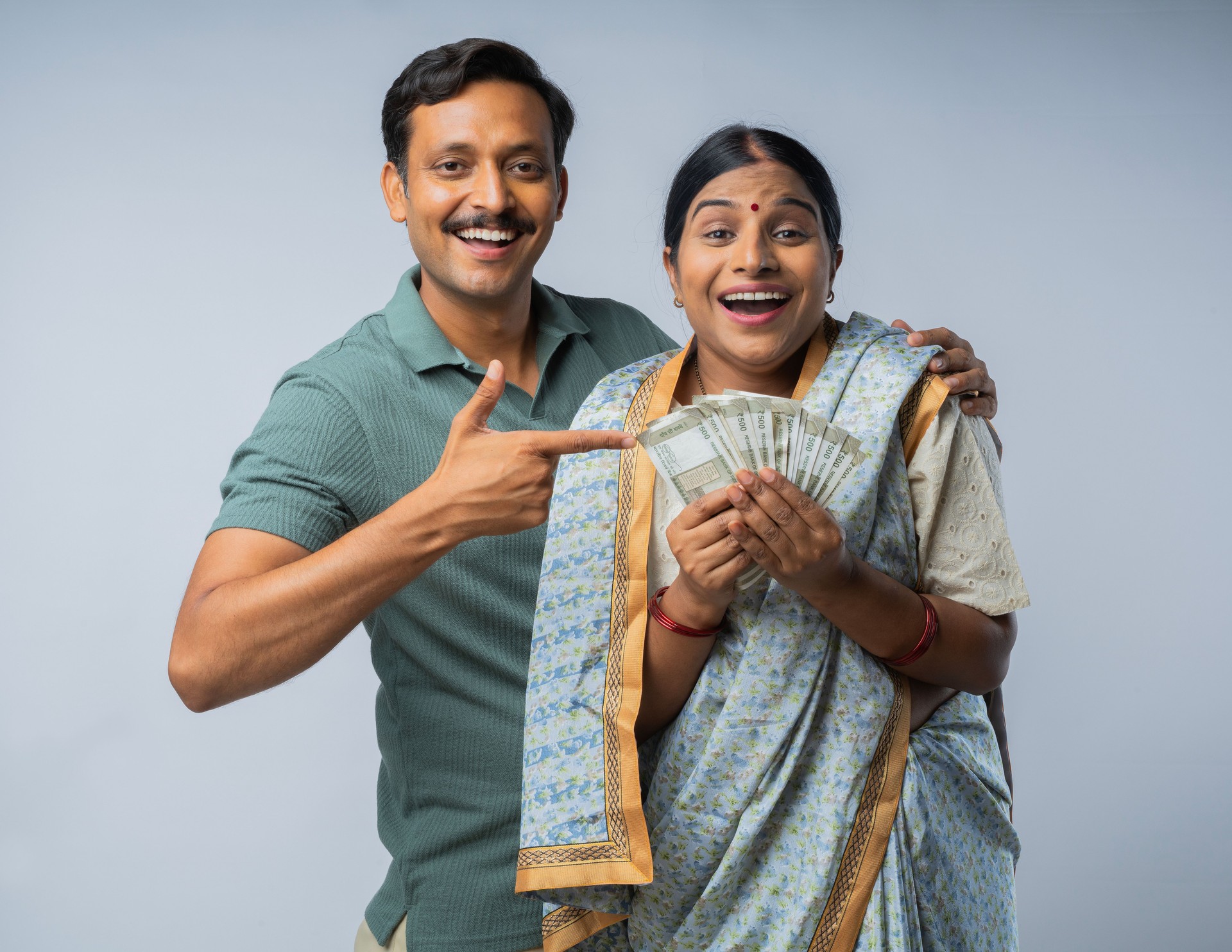 Happy couple with money standing on white background