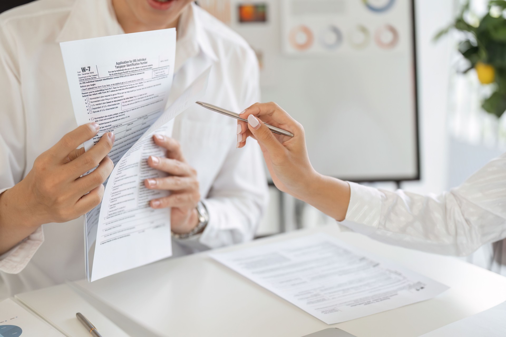 Tax professional reviewing W-2 form with a client, ensuring accurate tax filing and compliance.